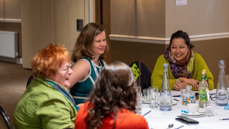 Four women sitting around a table. In focus on the right hand side is Dilraj Sokhi-Watson, Director at Equate Scotland and a graduate of the Data Skills for Work programme