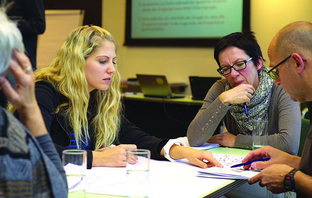 A group of people having a discussion at a meeting tablee