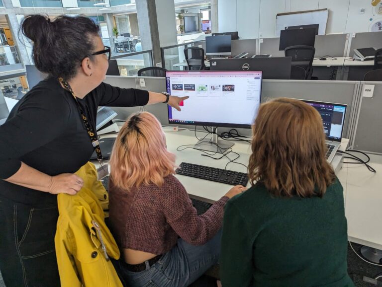 3 of the Data SKills for Work team working around one computer