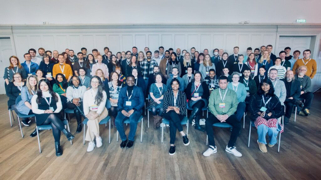 A group photo of our student group A group of 50 students representing our student cohort. The front row is sitting down and features a diverse range of students of different ages, skin colours and styles. Everyone is smiling brightly.