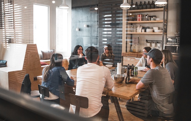 Colleagues gathered around a table in break area at work