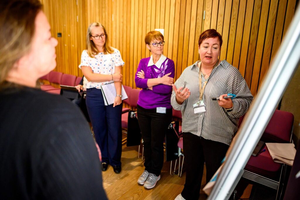 Research Data Scotland team gathered around a flipchart and discussing whats on it