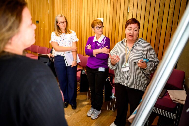 Research Data Scotland team gathered around a flipchart and discussing whats on it