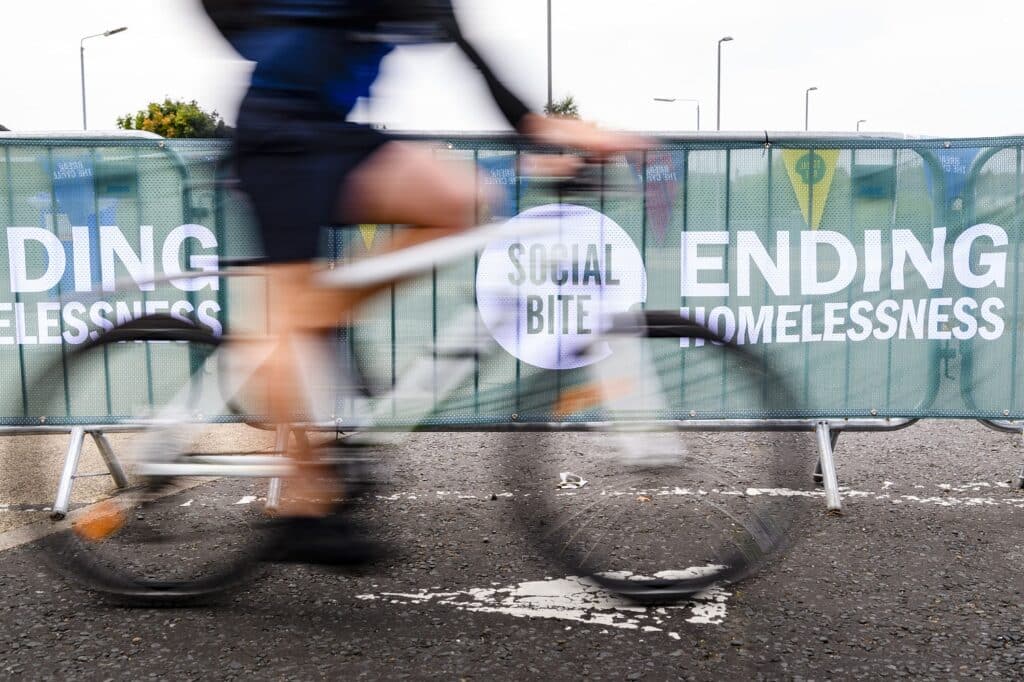 bike whizzing pst a social bite banner reading end homelessness