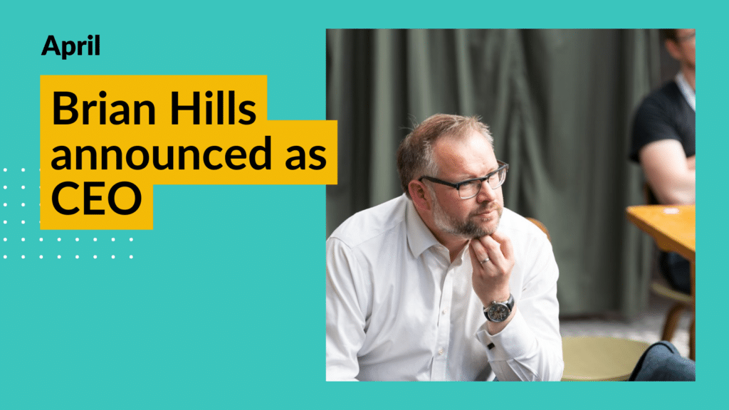 CEO Brian Hills looks pensively into the distance. He is wearing glasses and a white shirt. Overlay text reads "Brian Hills announced as CEO"