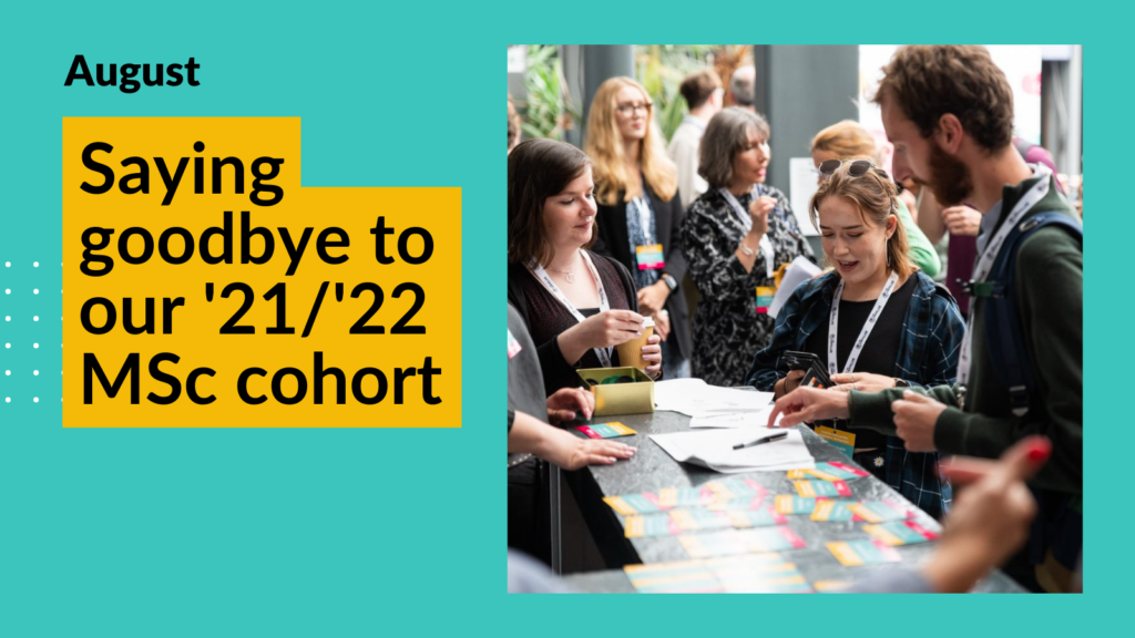 A group of students crowd around the registration desk at the Msc closing event to pick up their registration cards. Overlay text reads "Saying goodbye to our '21/'22 MSc cohort"