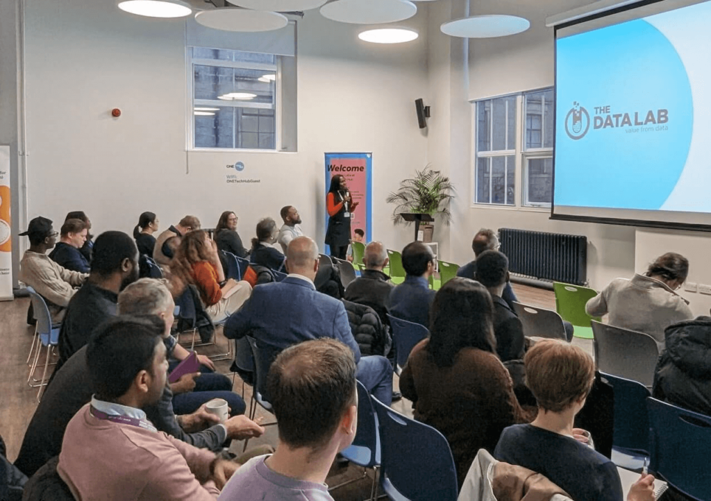 a crowd of people listenng to a talk with the data lab name on a screen